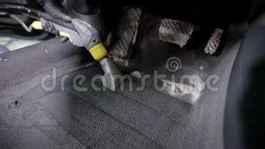 瓦舍曼正在铺汽车地毯，在车库里用泡沫清洗汽车内部，戴着手套